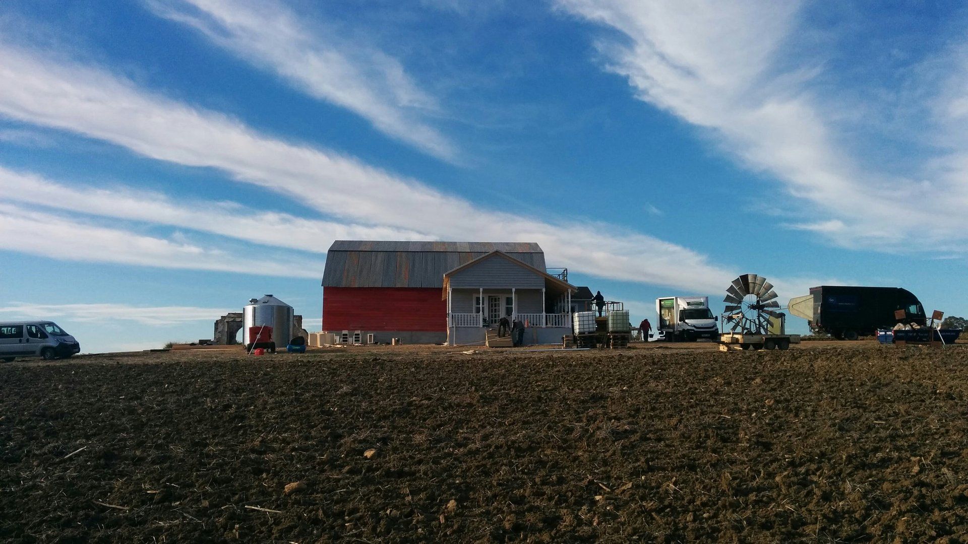 Una casa grande está situada encima de un campo de tierra.