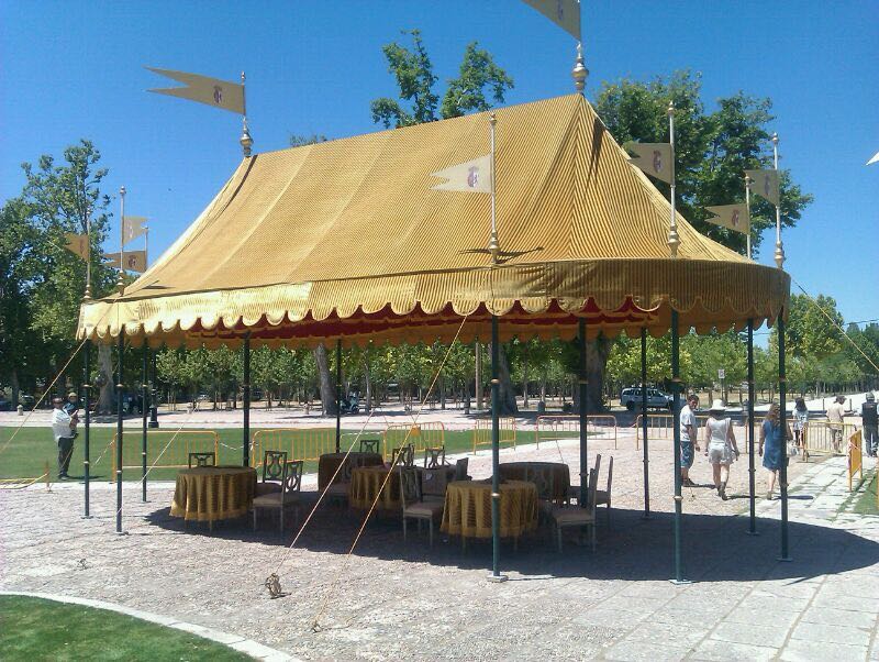 Una gran carpa con mesas y sillas debajo.