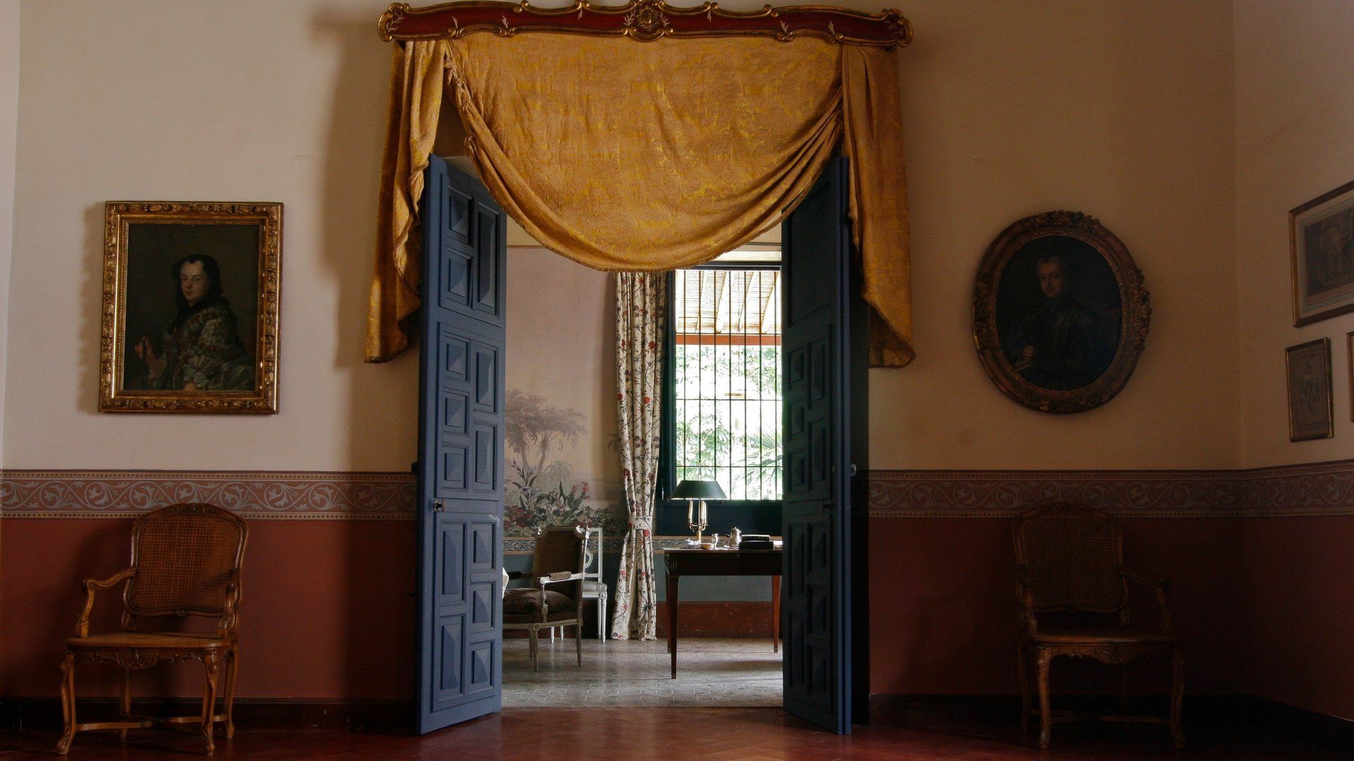 Una habitación con una puerta azul y un cuadro en la pared.