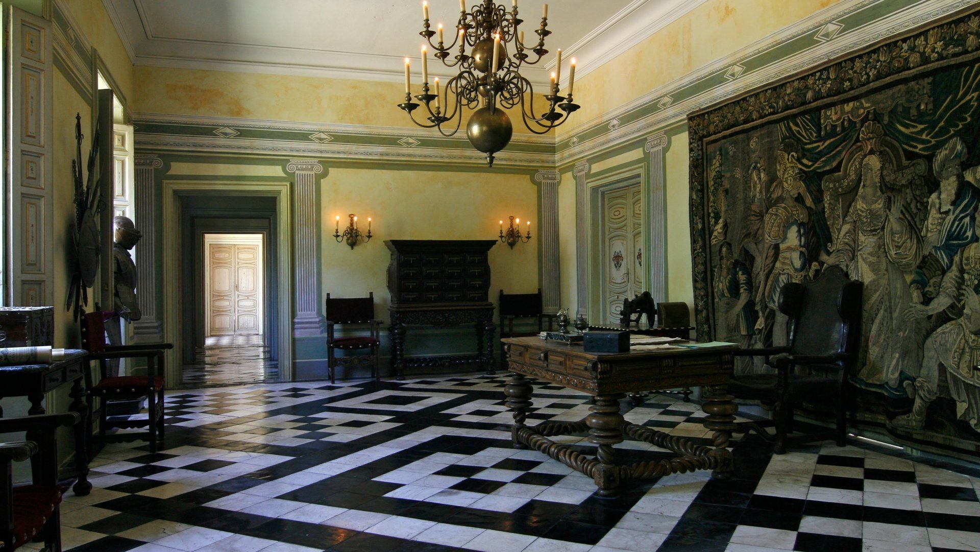 Una habitación grande con suelo de cuadros y una lámpara de araña.