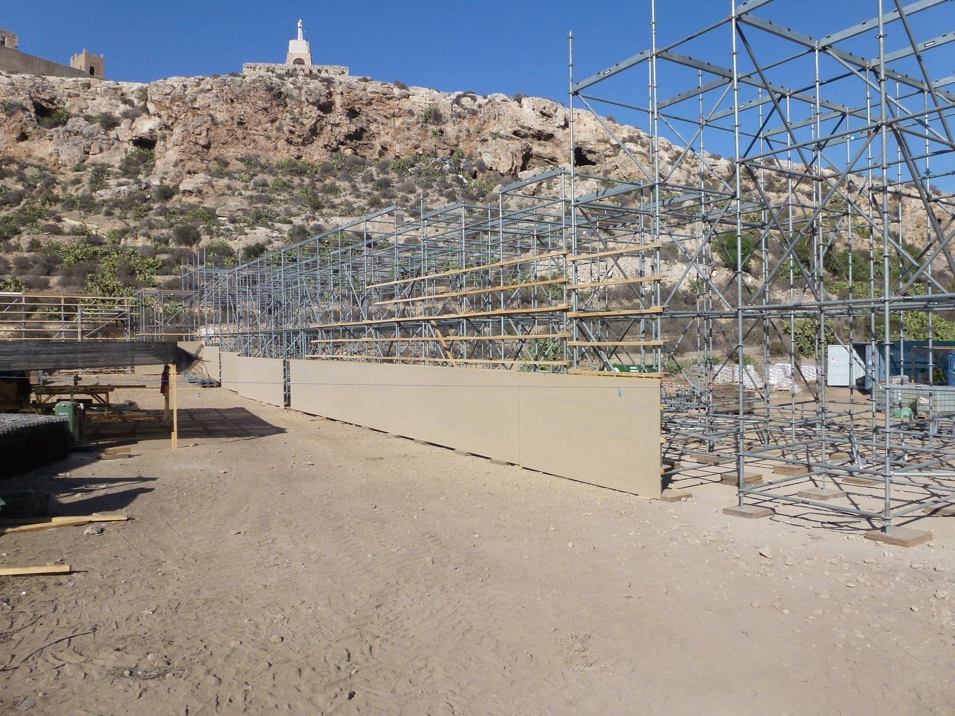 Una gran estructura de andamios en el desierto con una montaña al fondo.