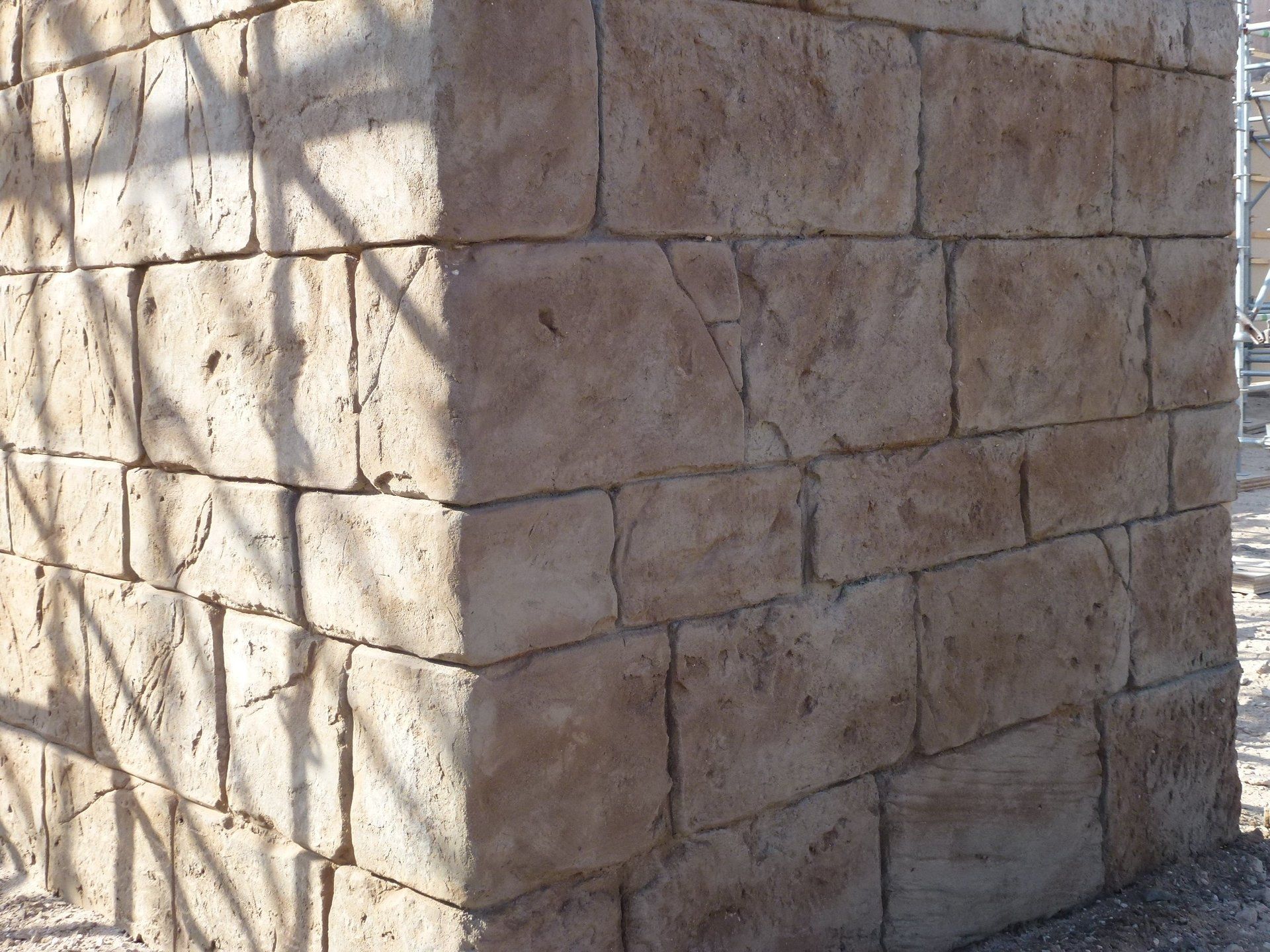 Una pared de ladrillos con la sombra de un árbol sobre ella