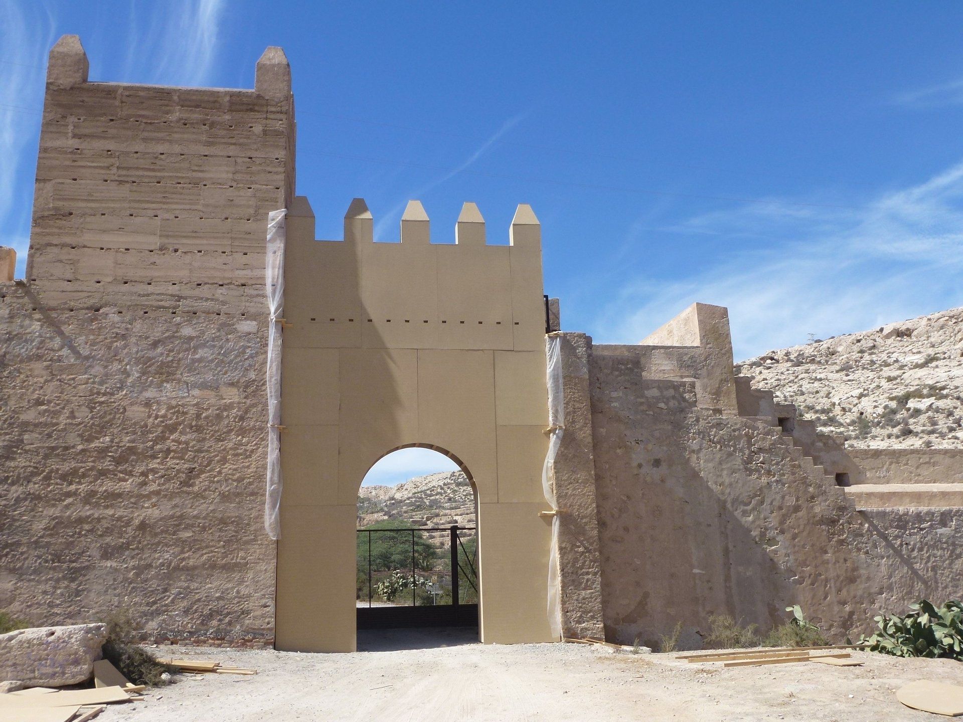 Un arco de piedra con un cielo azul al fondo.