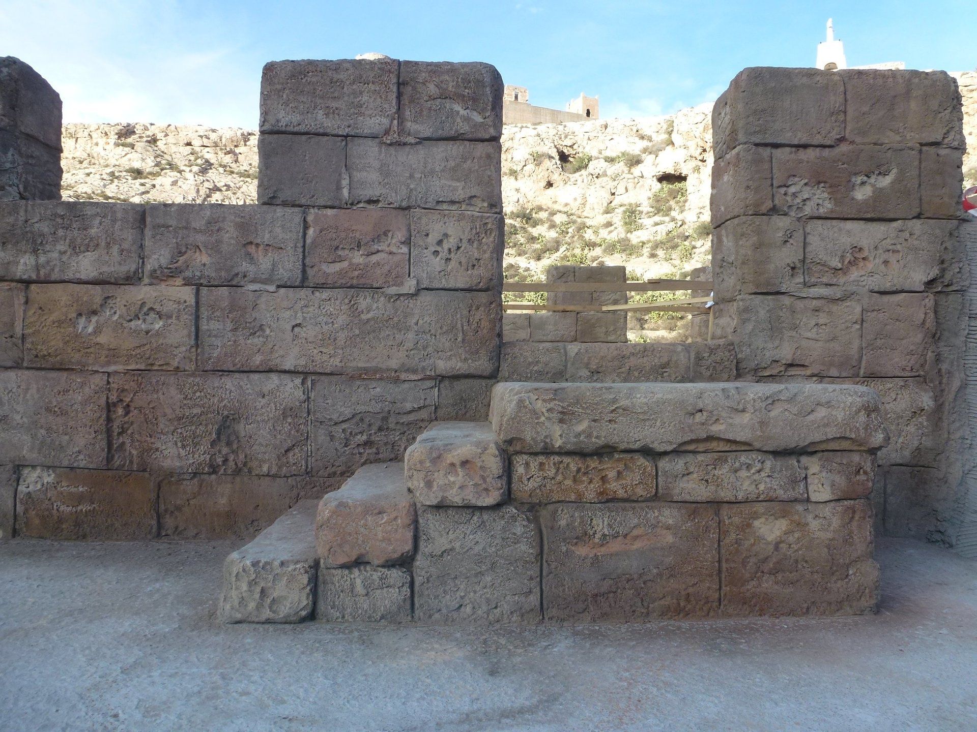 Un muro de piedra con escaleras que conducen hasta él.