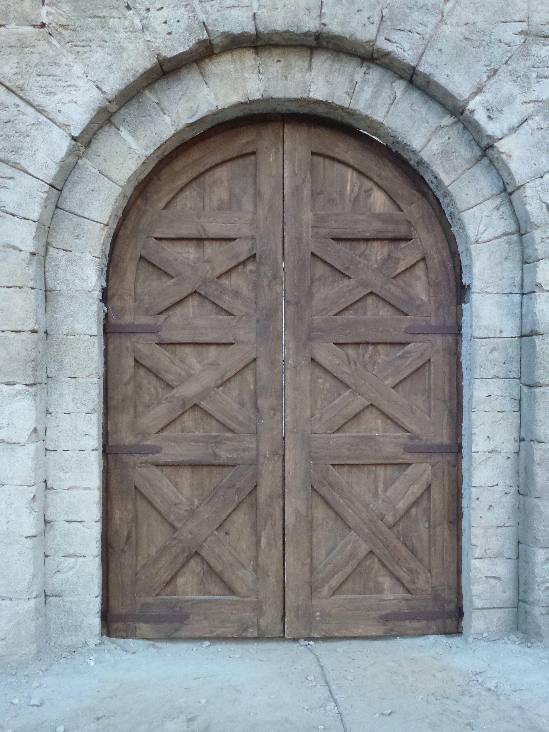 Un arco de piedra con una puerta de madera en el medio.
