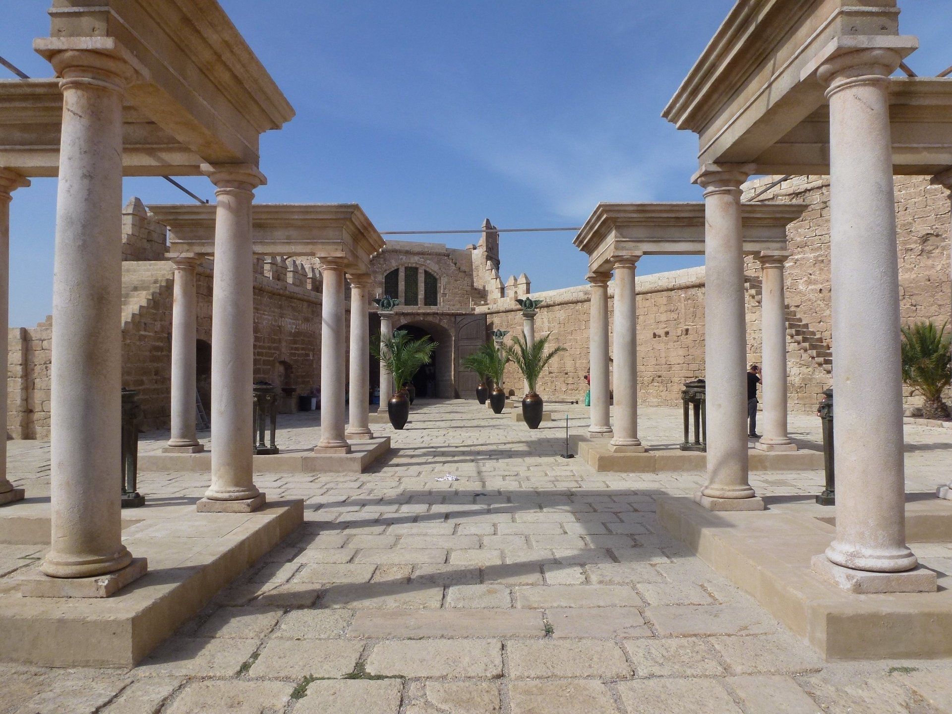 Una hilera de columnas de piedra frente a un edificio