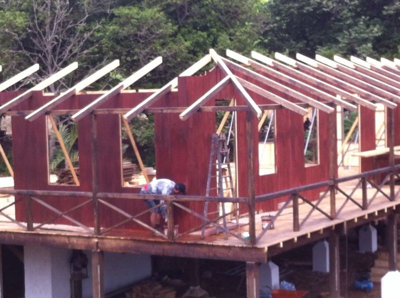 Un hombre está trabajando en el techo de una casa en construcción.