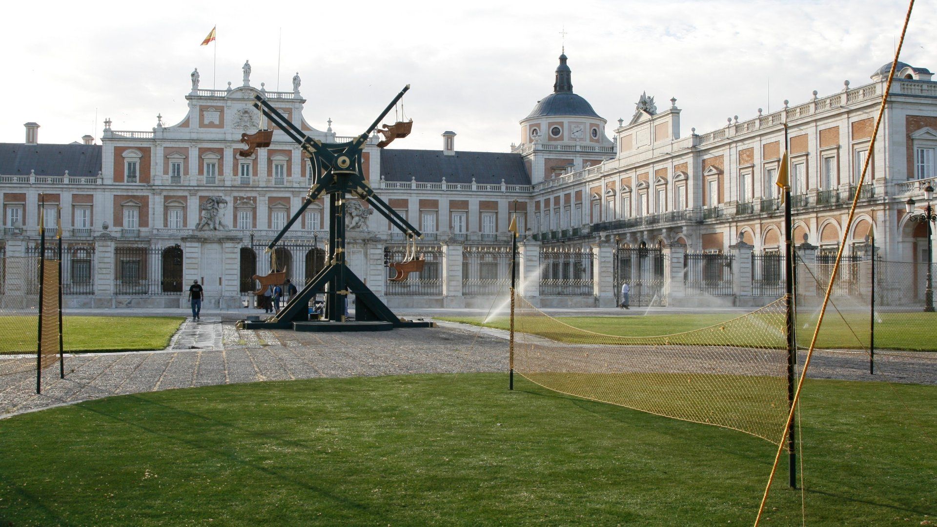 Un gran edificio con un molino de viento delante.