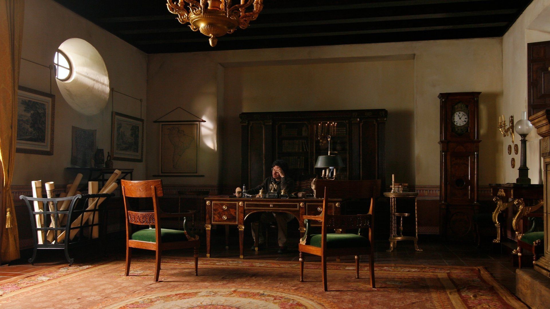 Un hombre está sentado en un escritorio en una sala de estar.