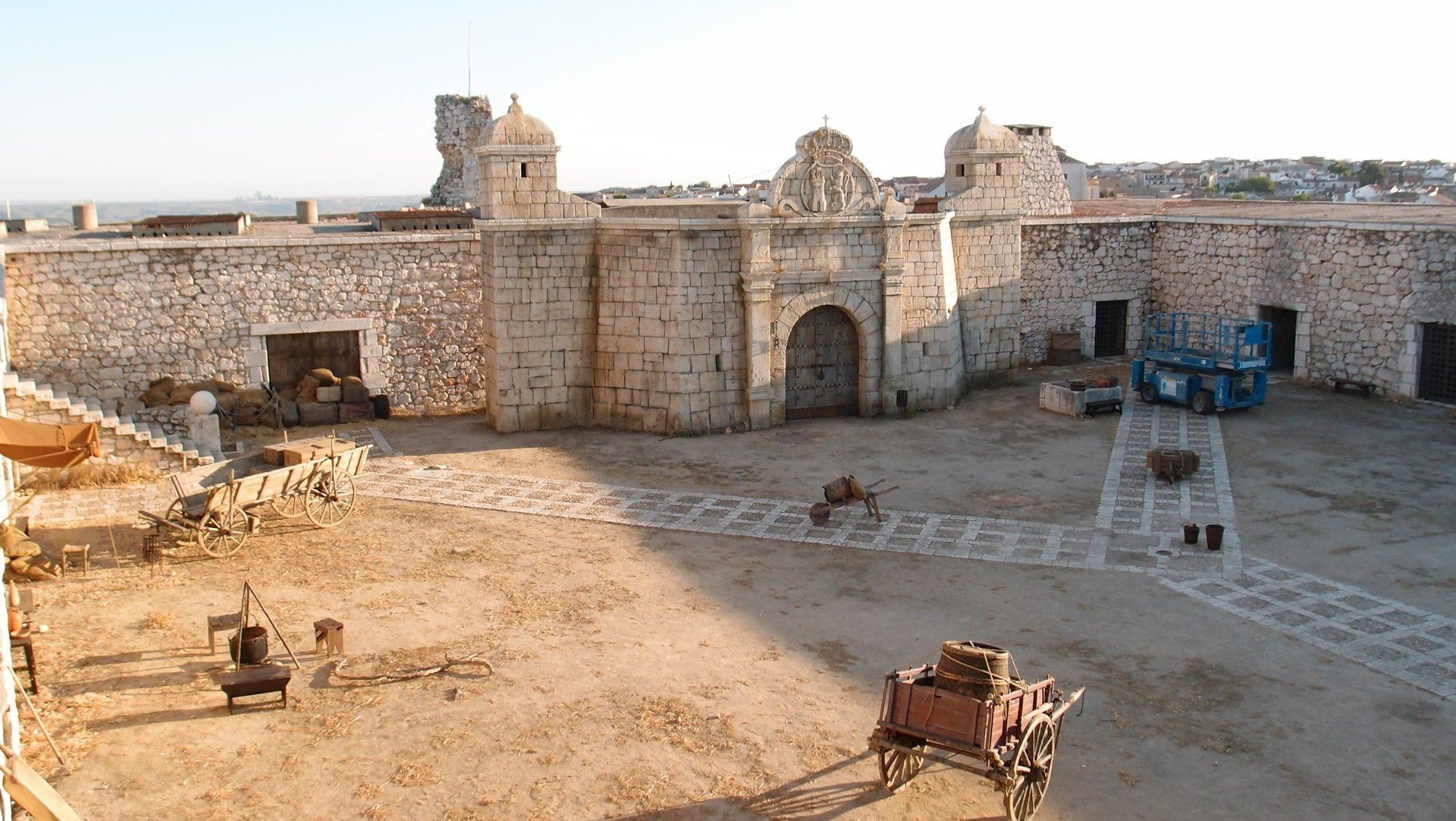 Un gran edificio de piedra con un carro delante.