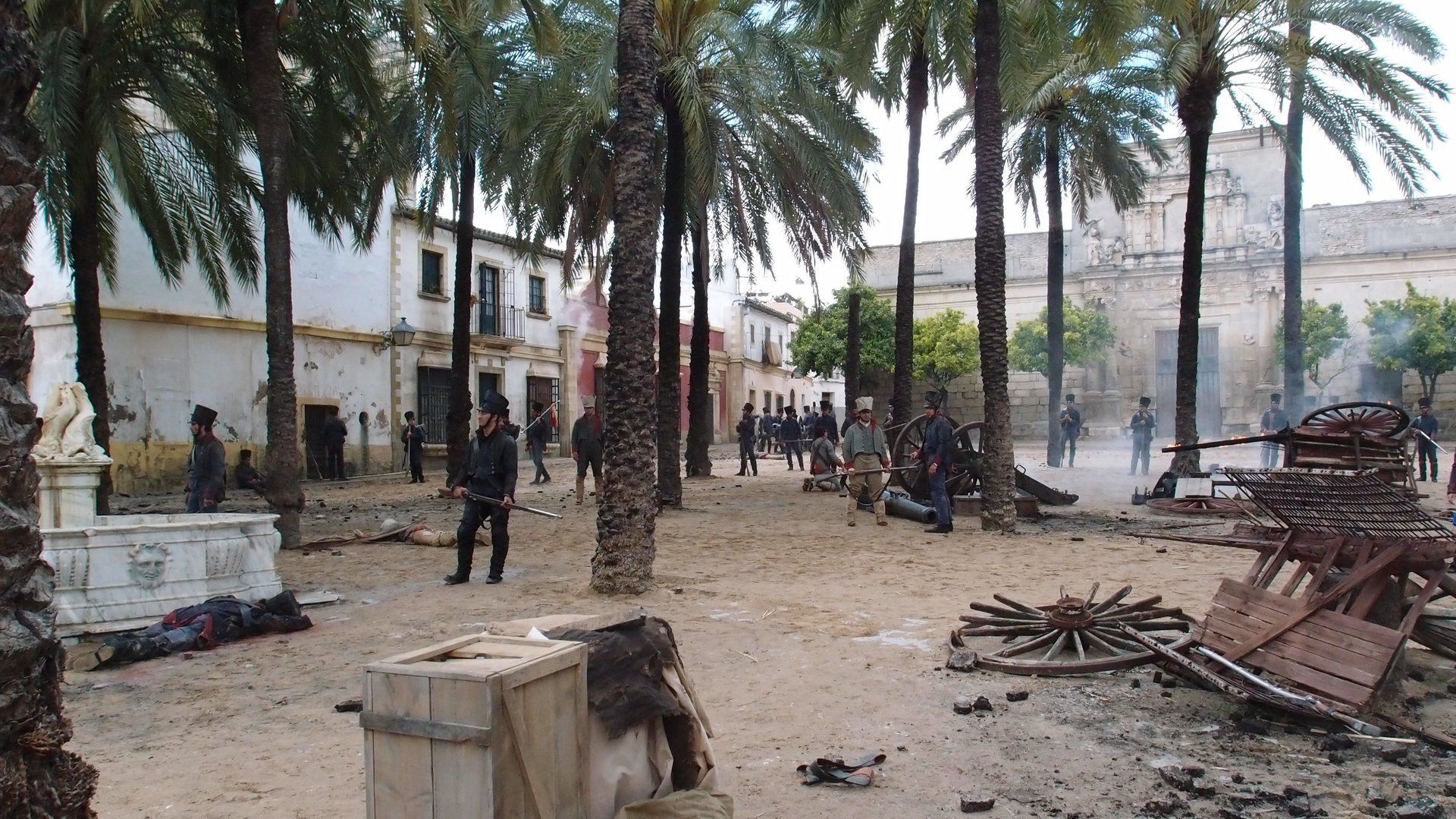 Un grupo de personas está de pie en un parque rodeado de palmeras.