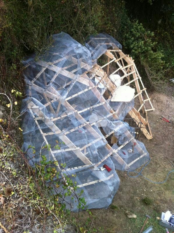Un gran trozo de plástico cubre una estructura de madera.