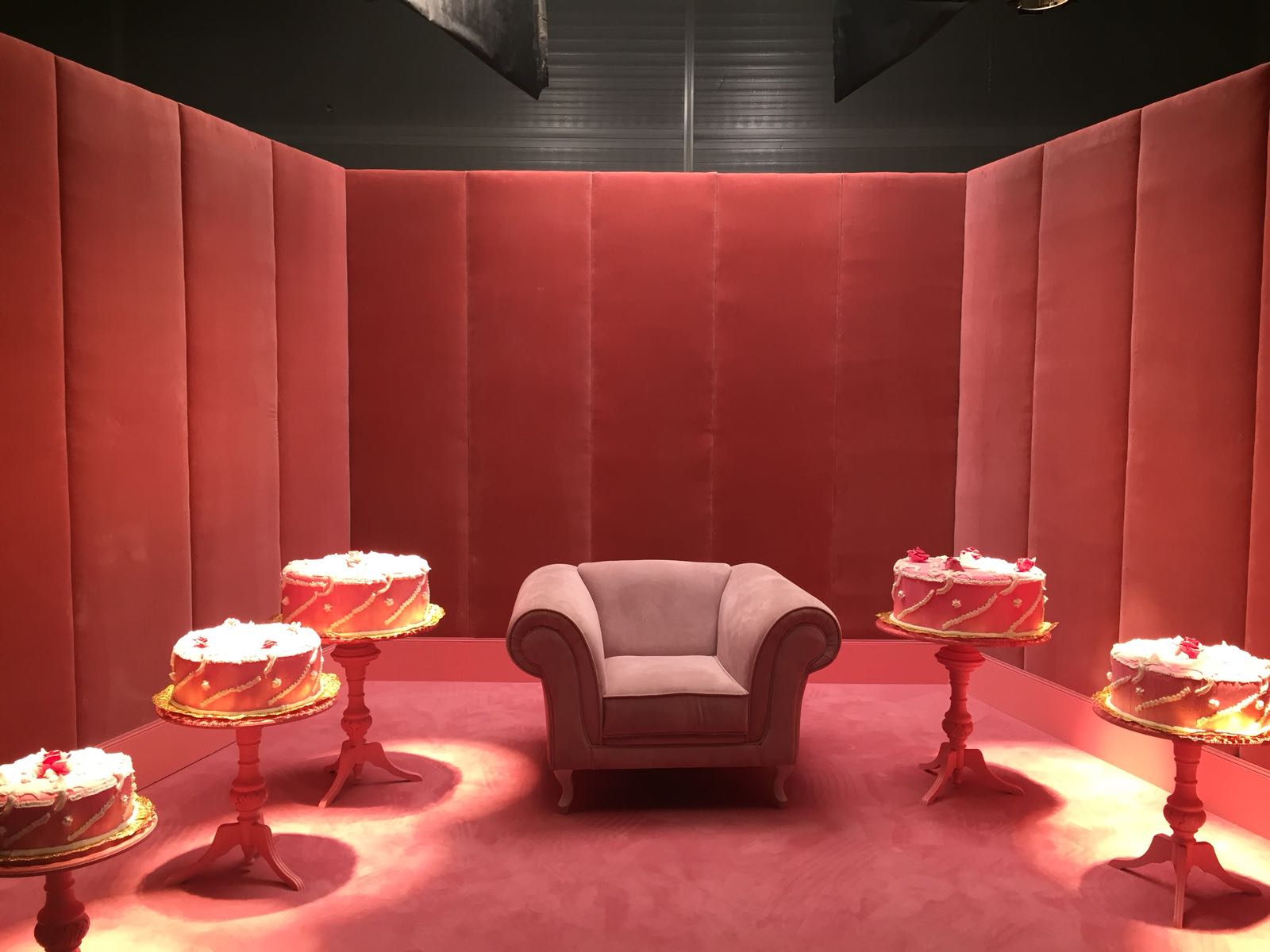 Una habitación con una silla y pasteles en las mesas.