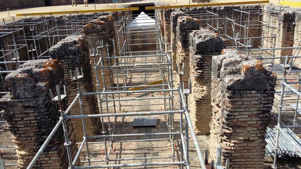 Una hilera de andamios rodea un edificio de ladrillo.