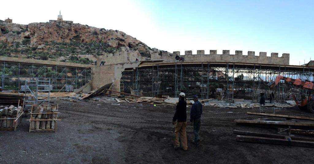 Dos hombres de pie frente a un edificio en construcción