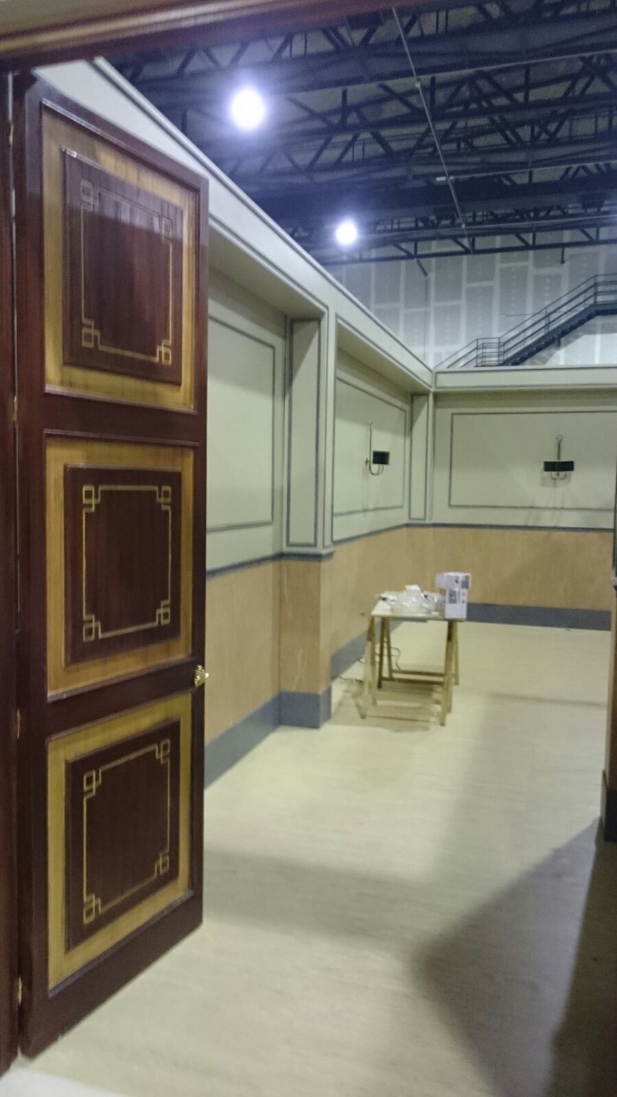 Una habitación con una mesa y una puerta que está abierta