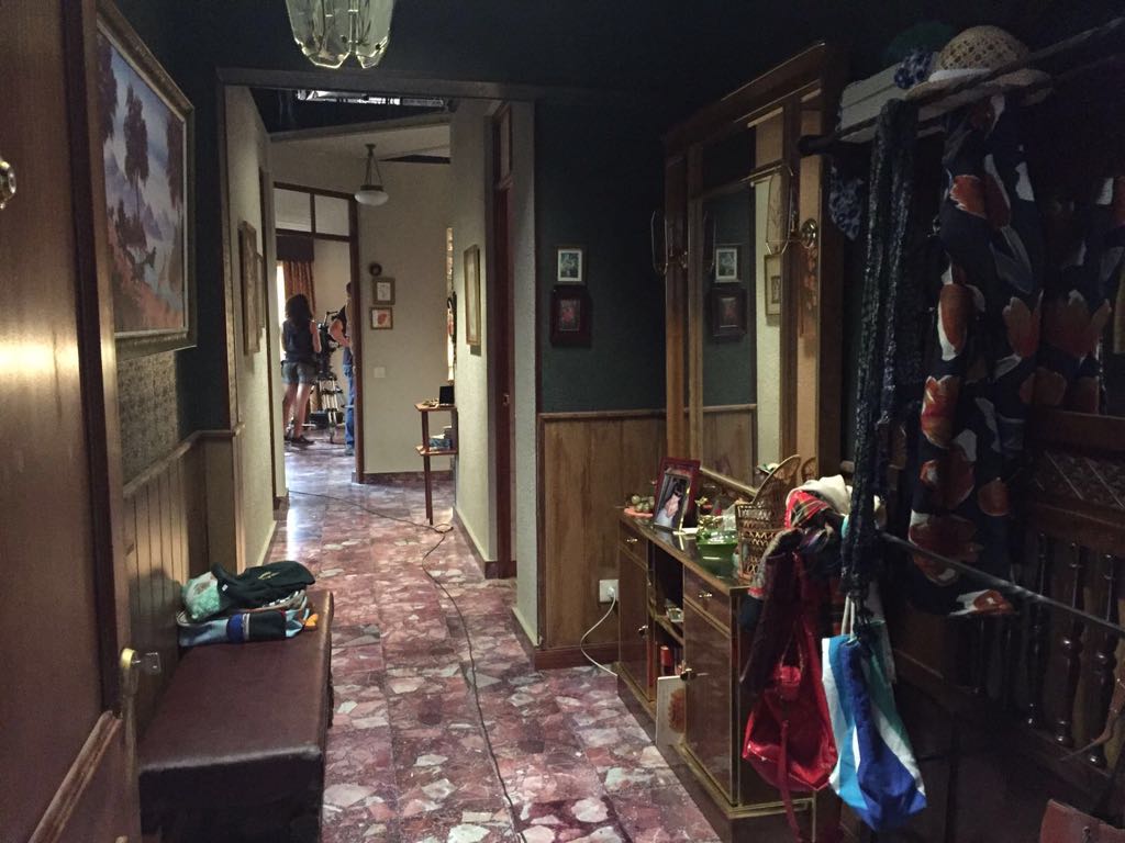 Un pasillo en una casa con un banco y una mesa.