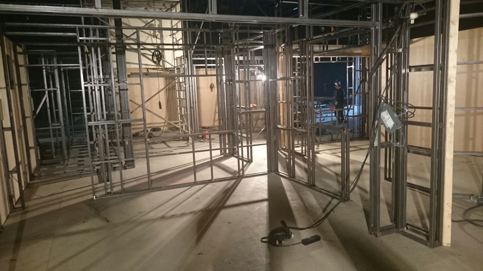 Una habitación con muchos marcos de metal y una luz en el suelo.