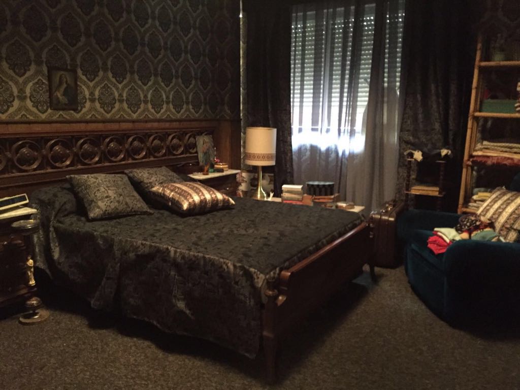 Un dormitorio con una cama grande y una silla.