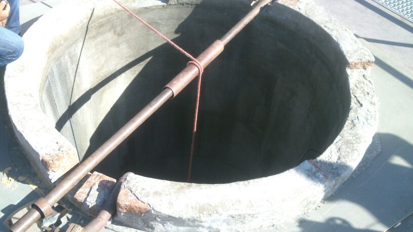 Un hombre está parado junto a un gran agujero en el suelo.