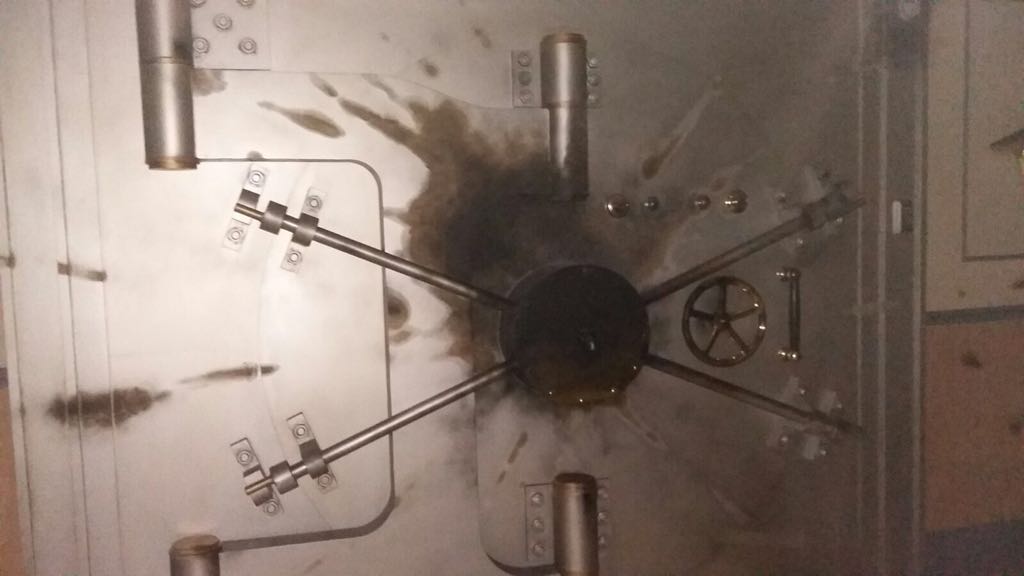 Un primer plano de una puerta de bóveda con un agujero en ella.