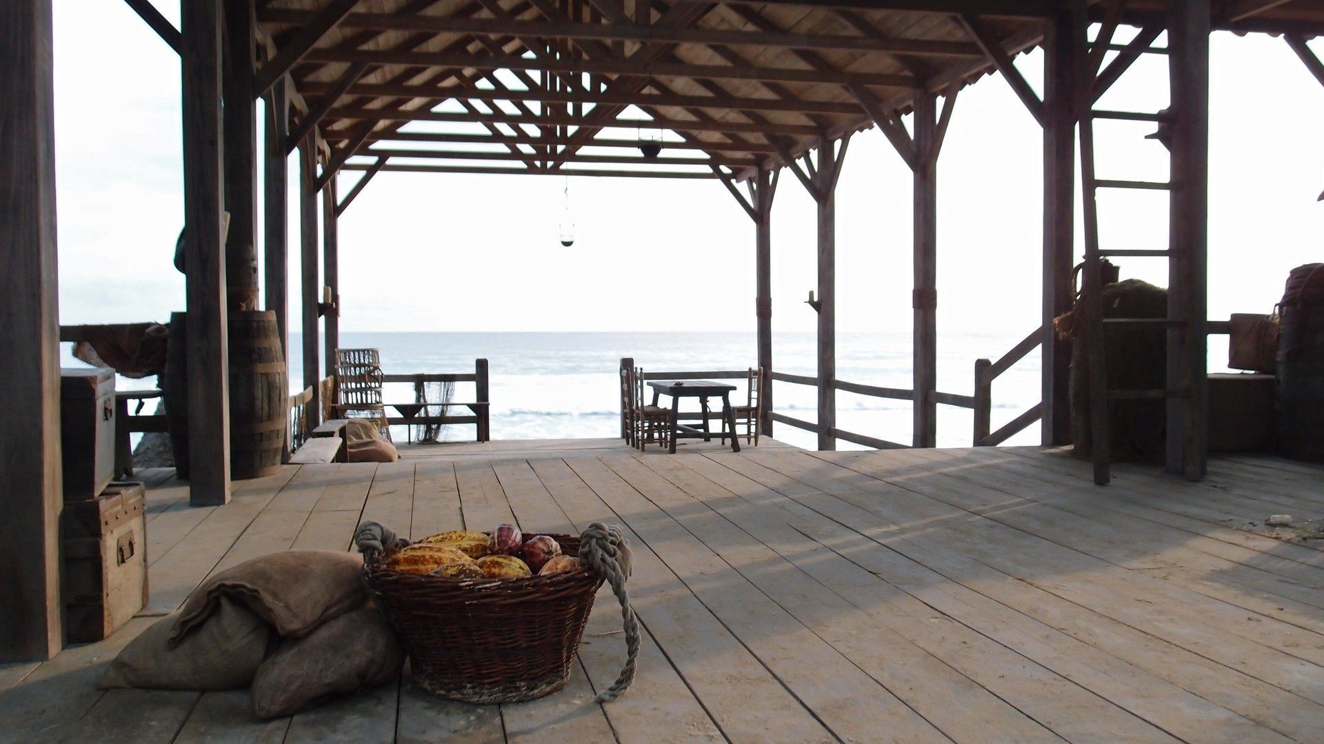 Una terraza de madera con una cesta de fruta encima.