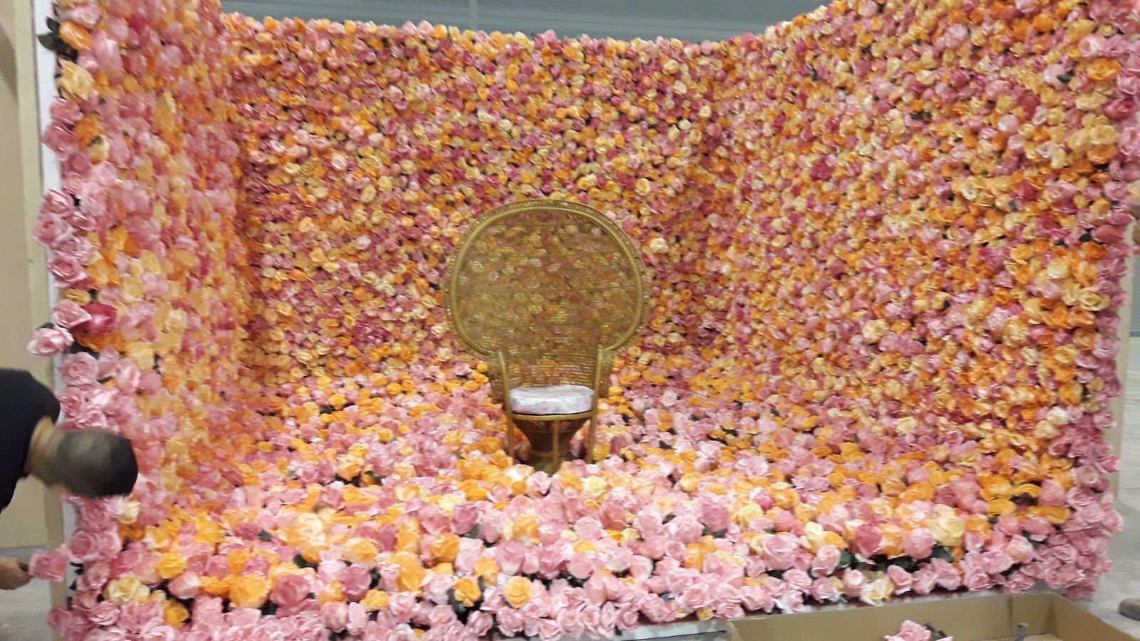 Una silla está sentada frente a una pared de flores.