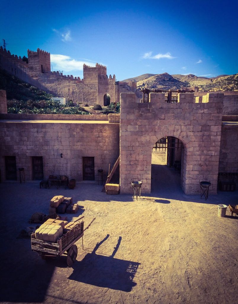 Un carro con cajas está estacionado frente a un edificio de piedra.