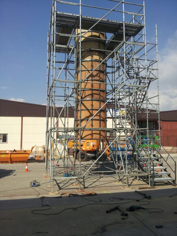 Un gran objeto cilíndrico está rodeado de andamios y escaleras.