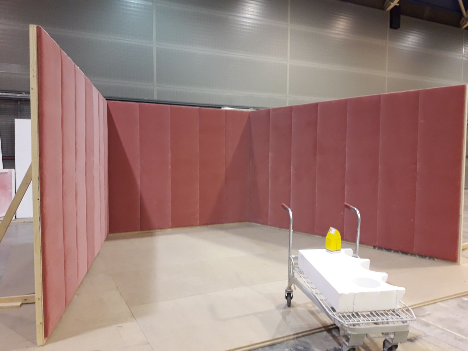 Una habitación con paredes rojas y un carrito dentro.