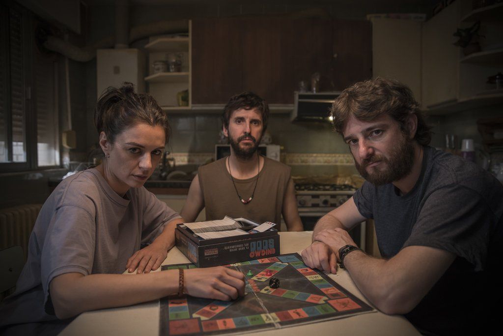 Un grupo de personas está sentada en una mesa jugando un juego de mesa.