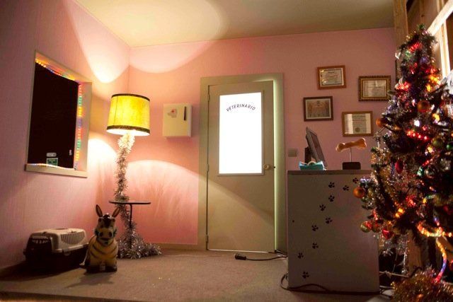 Un perro está parado en una habitación con un árbol de Navidad y una lámpara.