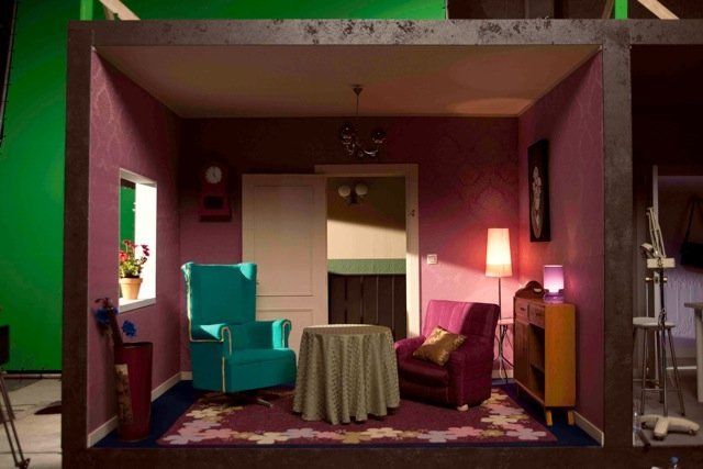 Una sala de estar con una pantalla verde detrás.