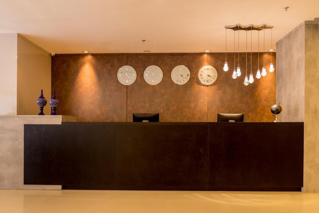 Recepção do hotel com relógios indicando diferentes fusos horários.