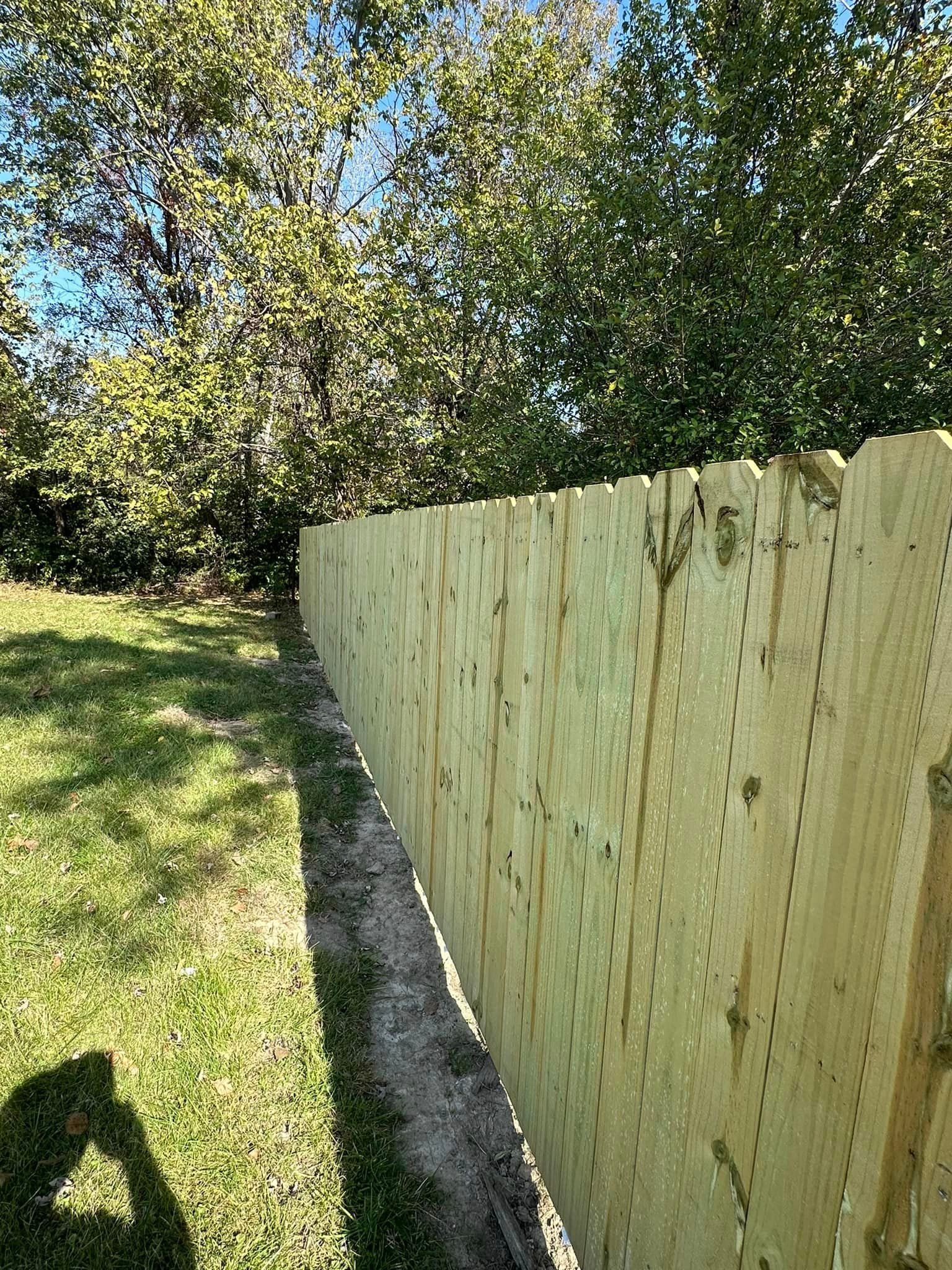 A wooden fence is sitting in the middle of a grassy field.