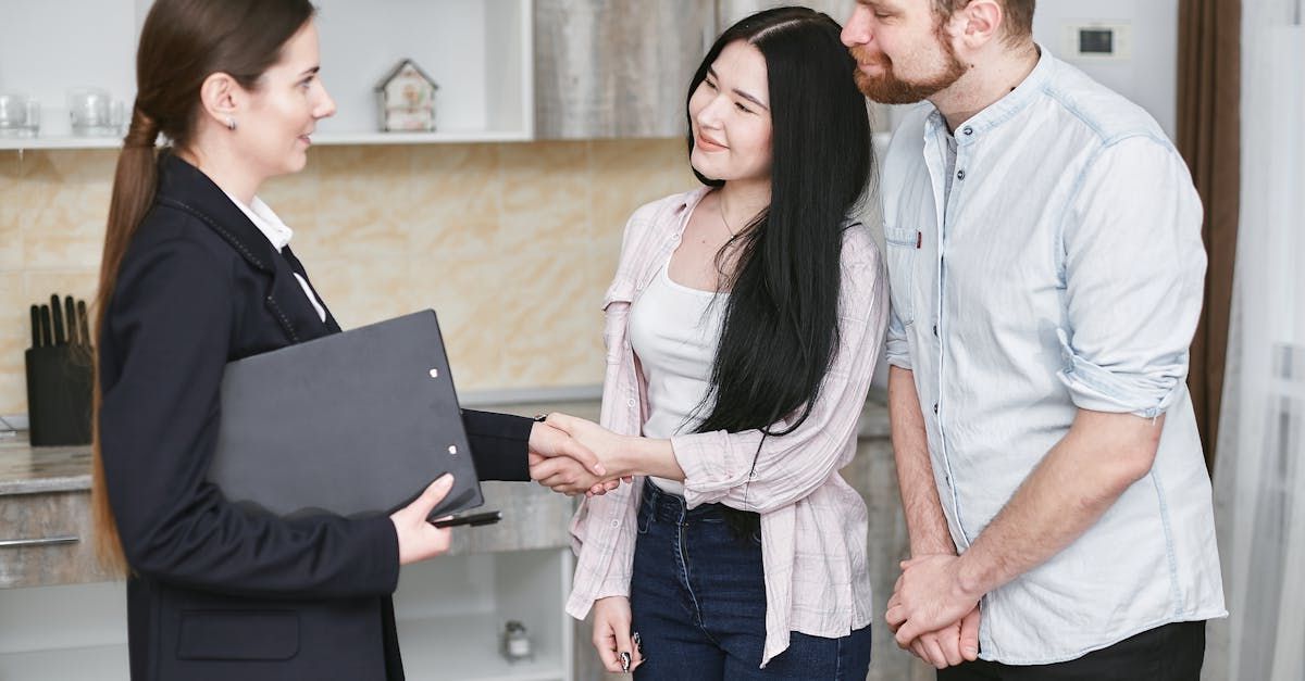 An estate agent is shaking hands with a couple of homebuyers