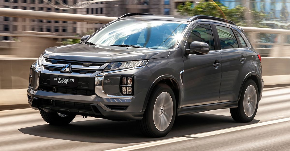 Gray Mitsubishi Outlander Sport SUV driving on a city road.