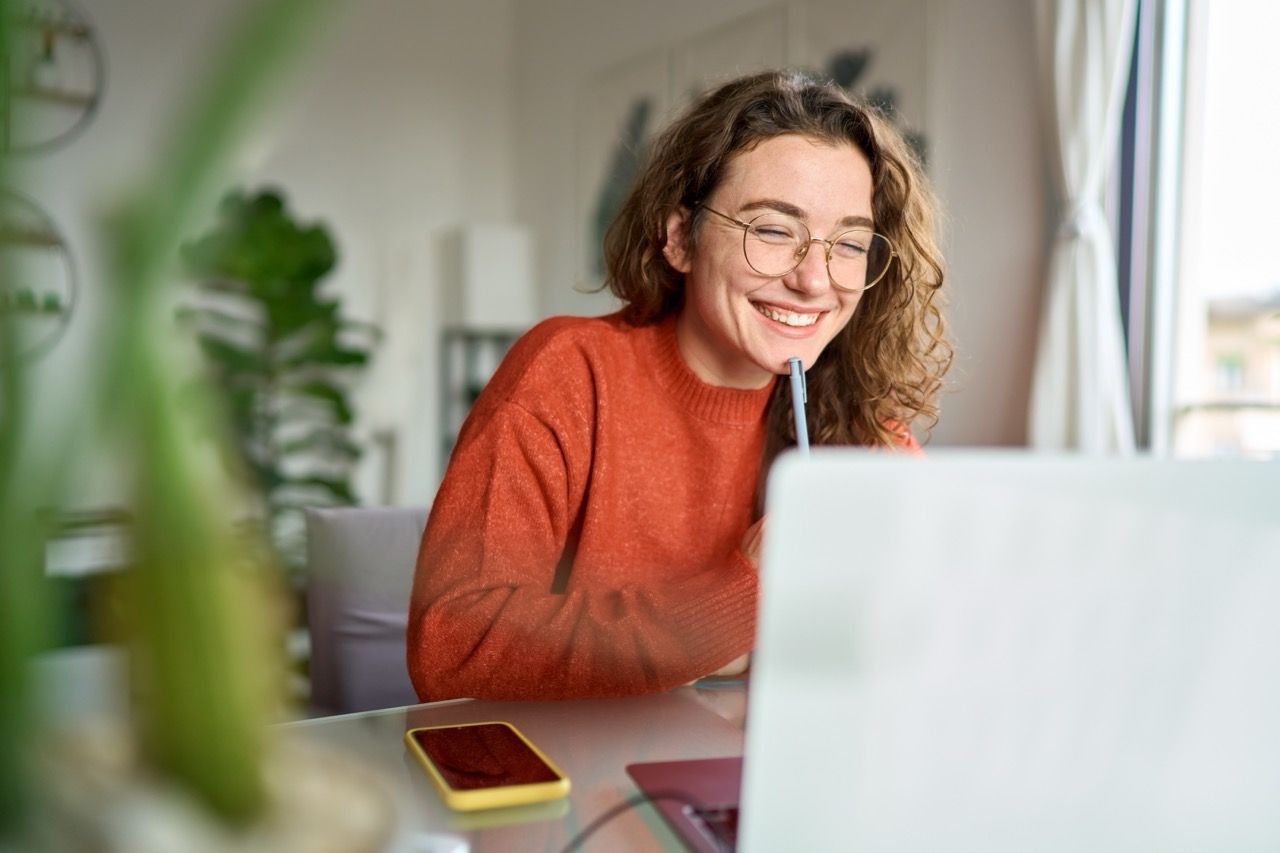 student looking and smiling at laptop