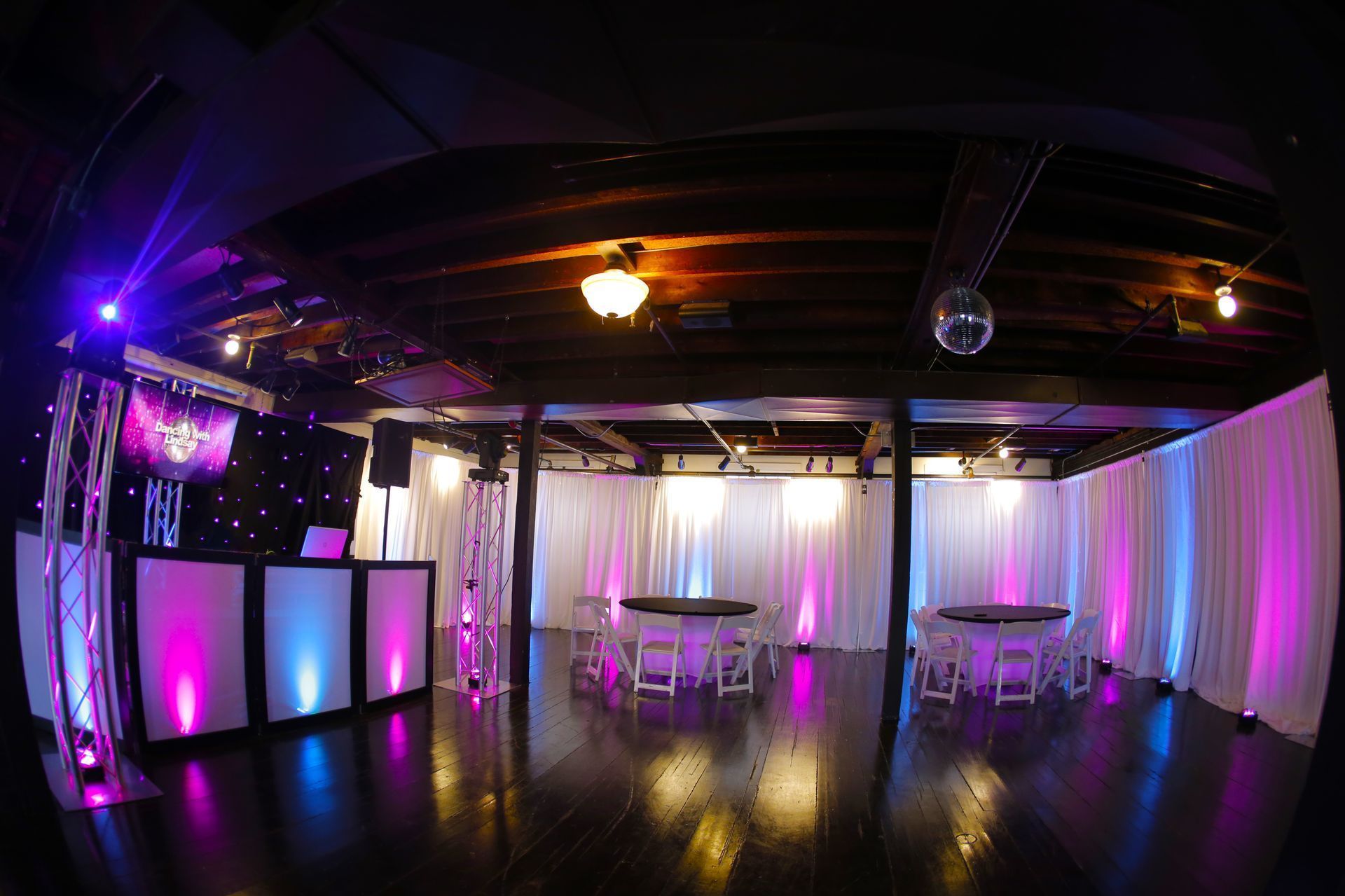 Harvard Boat Club  room with Lit Tables, uplighting, Pipe and Drape  chairs and a dj booth with Fiber Optic Backdrop and LED 65