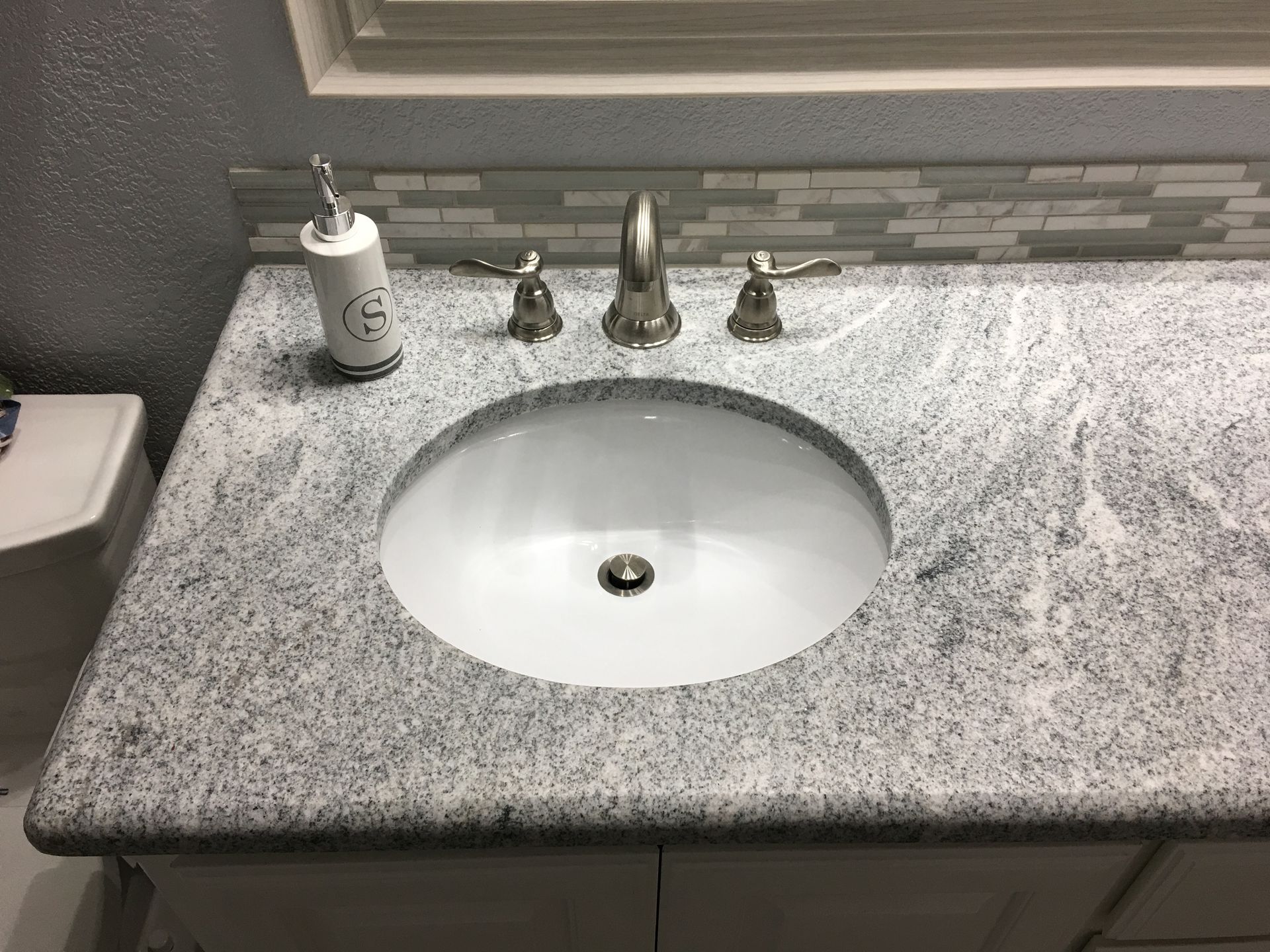 A bathroom sink with a soap dispenser on top of it.