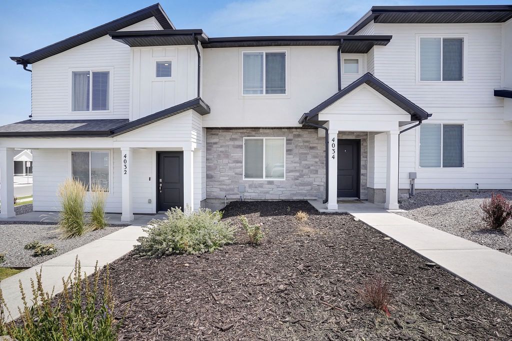 Exterior view of a two-story apartment building with two front entry doors and minimalist landscaping.