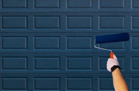 using a roller brush to paint a garage door DIY