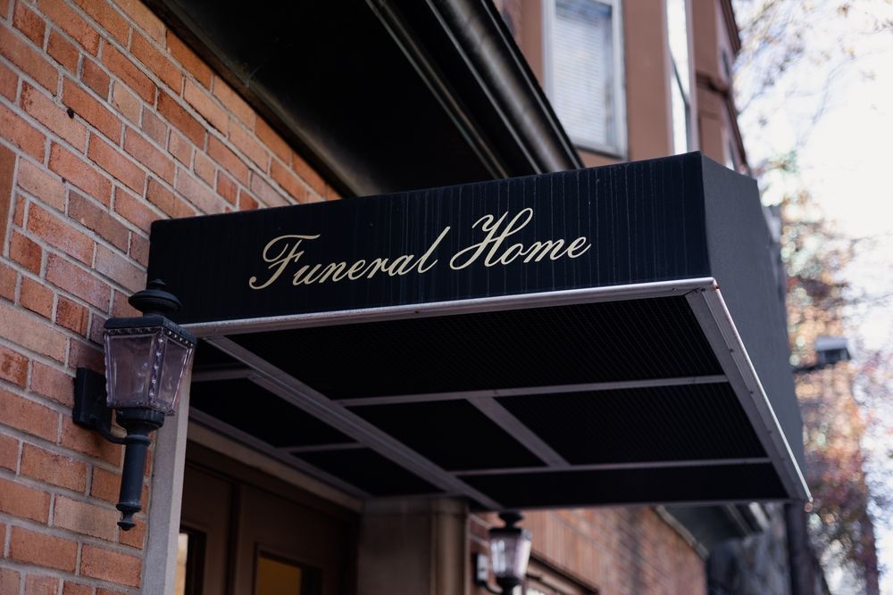 Funeral home entrance: black awning with gold lettering over a brick building.