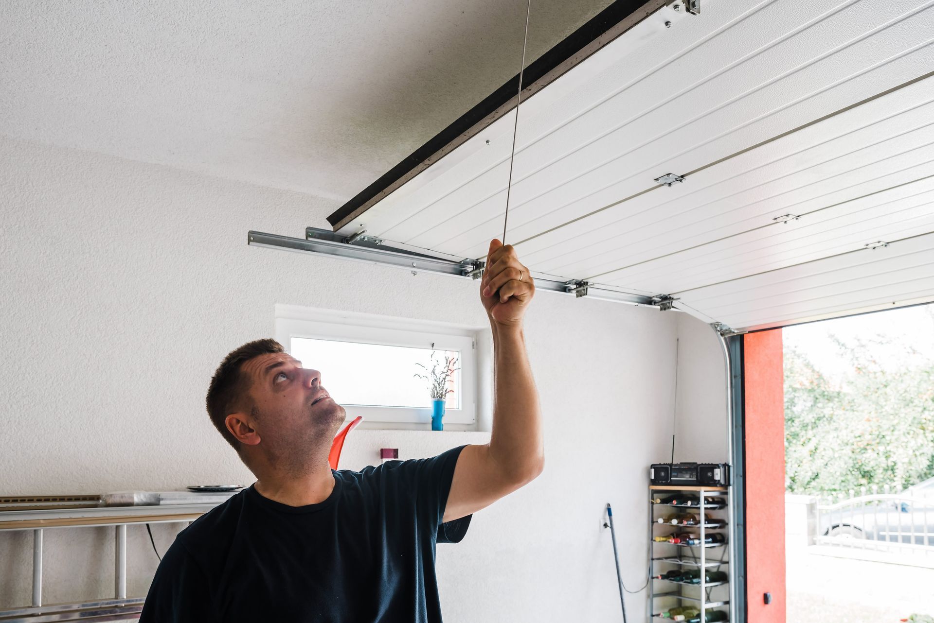 a man is working to repair a garage door that will not close 