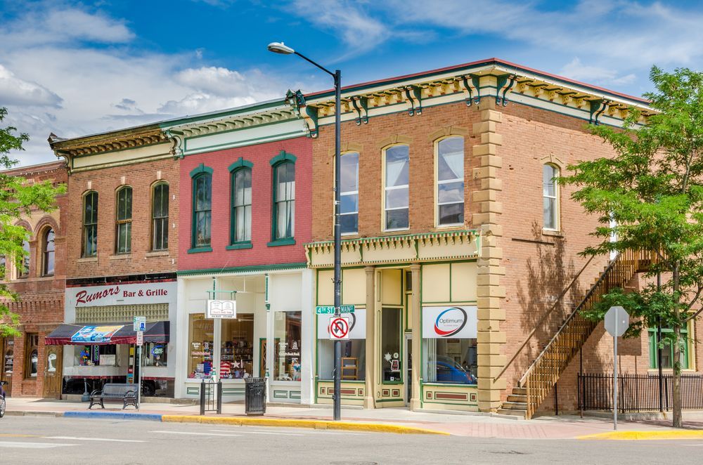 A row of brick buildings on the corner of a city street.