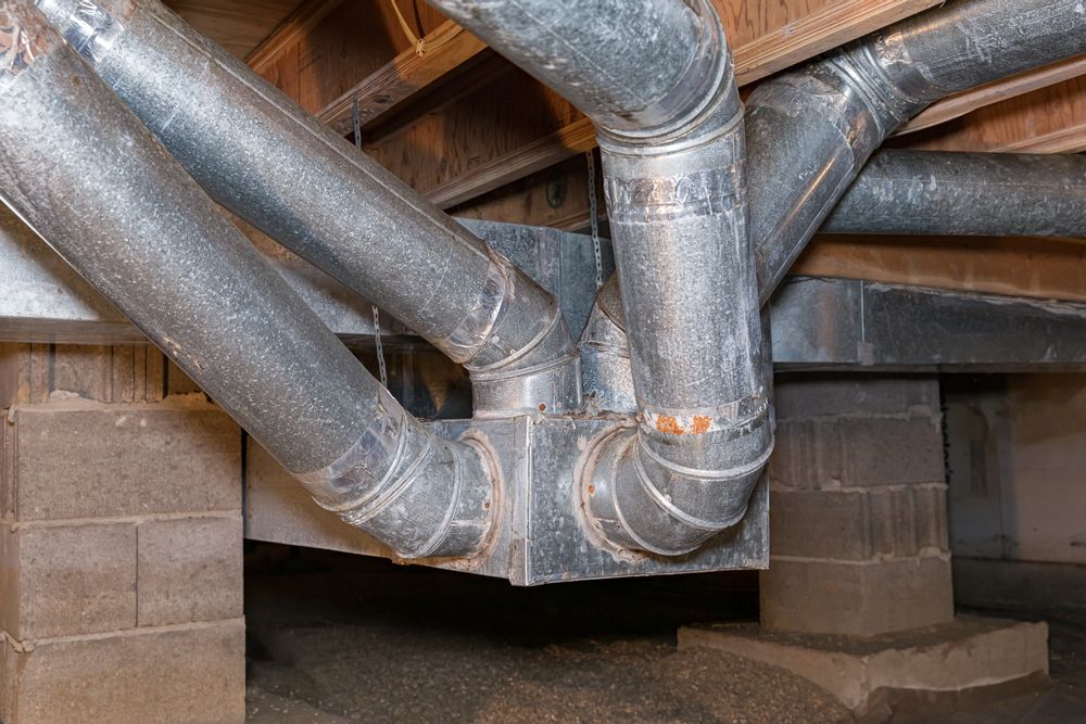 A bunch of metal pipes are connected to each other in a basement.