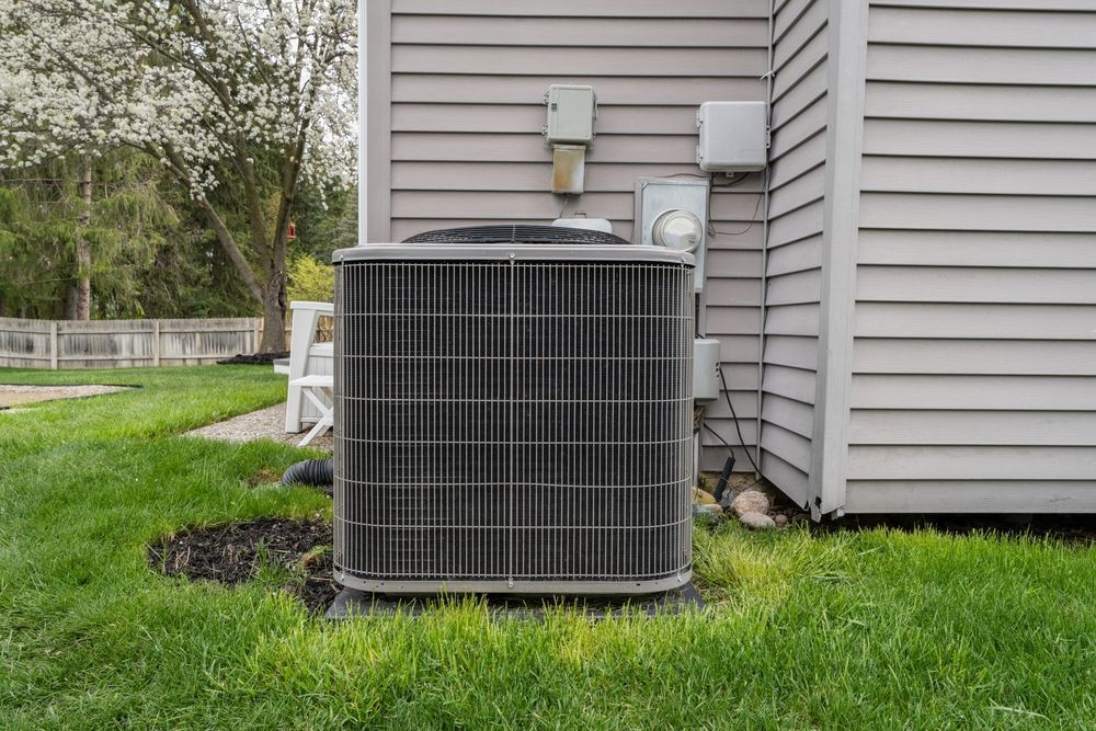 An air conditioner is sitting on the side of a house.