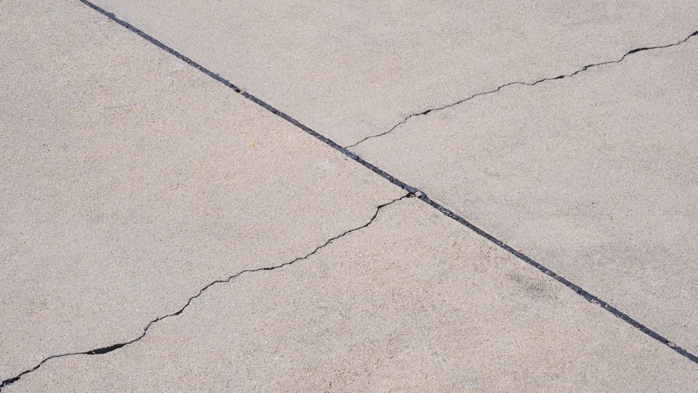 A close up of a cracked concrete drive way