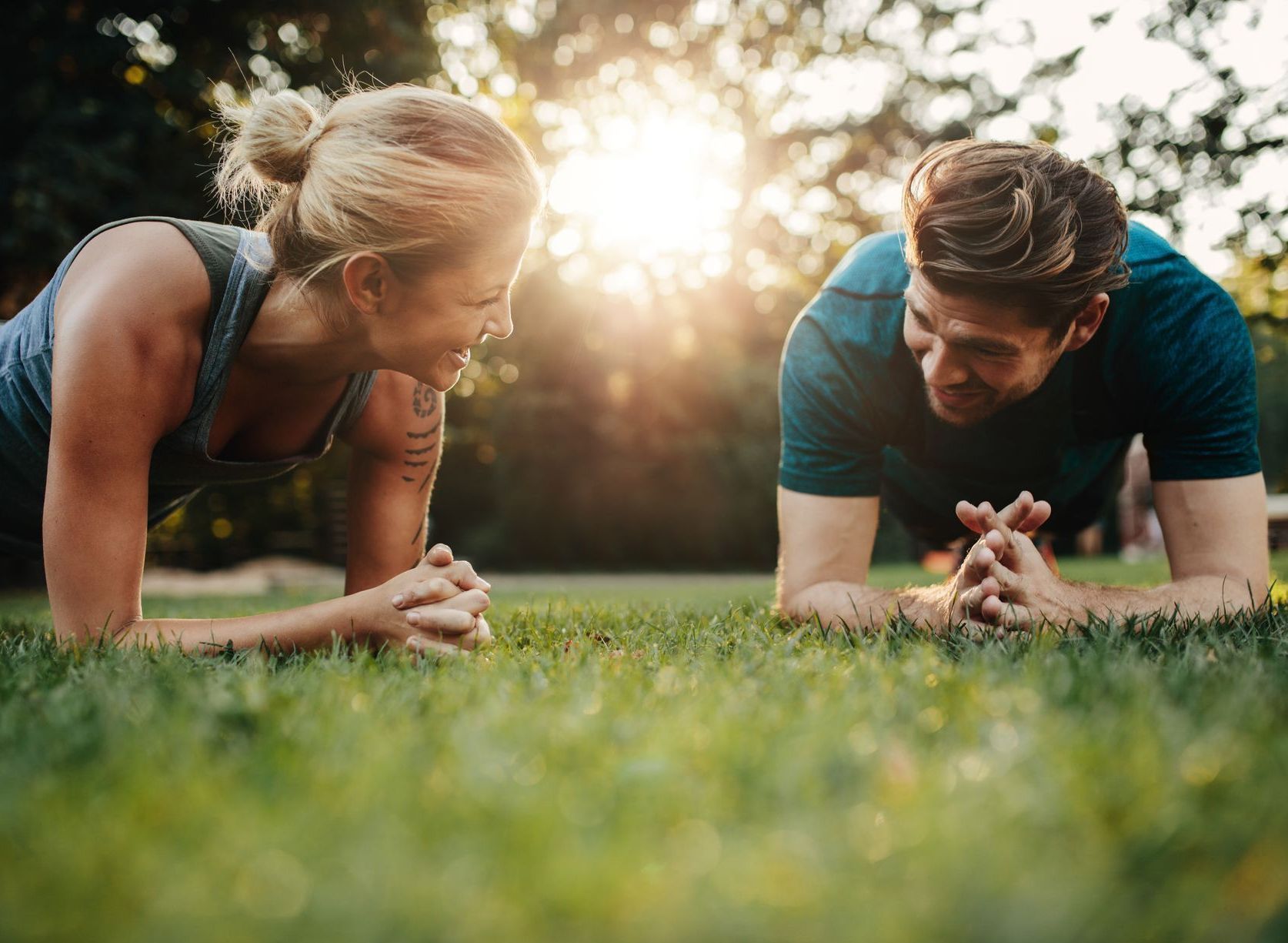 the partners practicing planks in their pre-workout routine