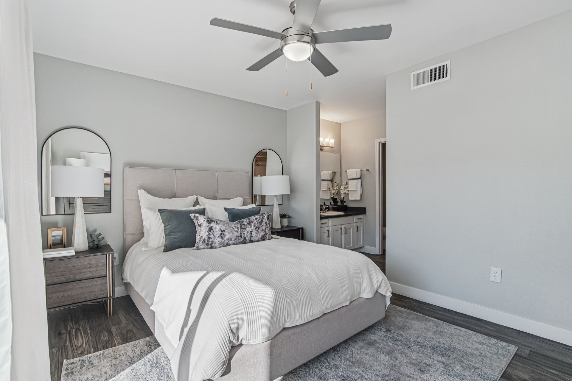 Bedroom with gray walls, bed, and ensuite bathroom.